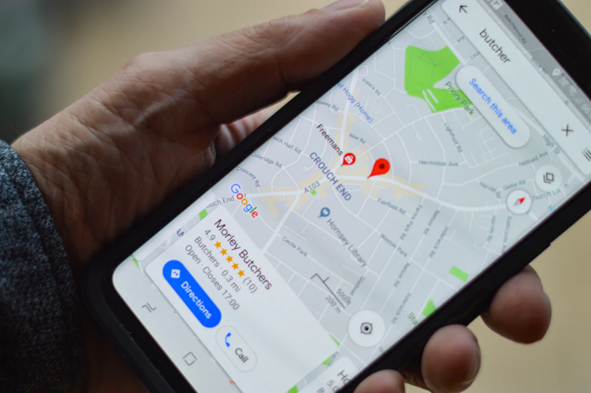 Person holding a smartphone showing a Google map for a local business search